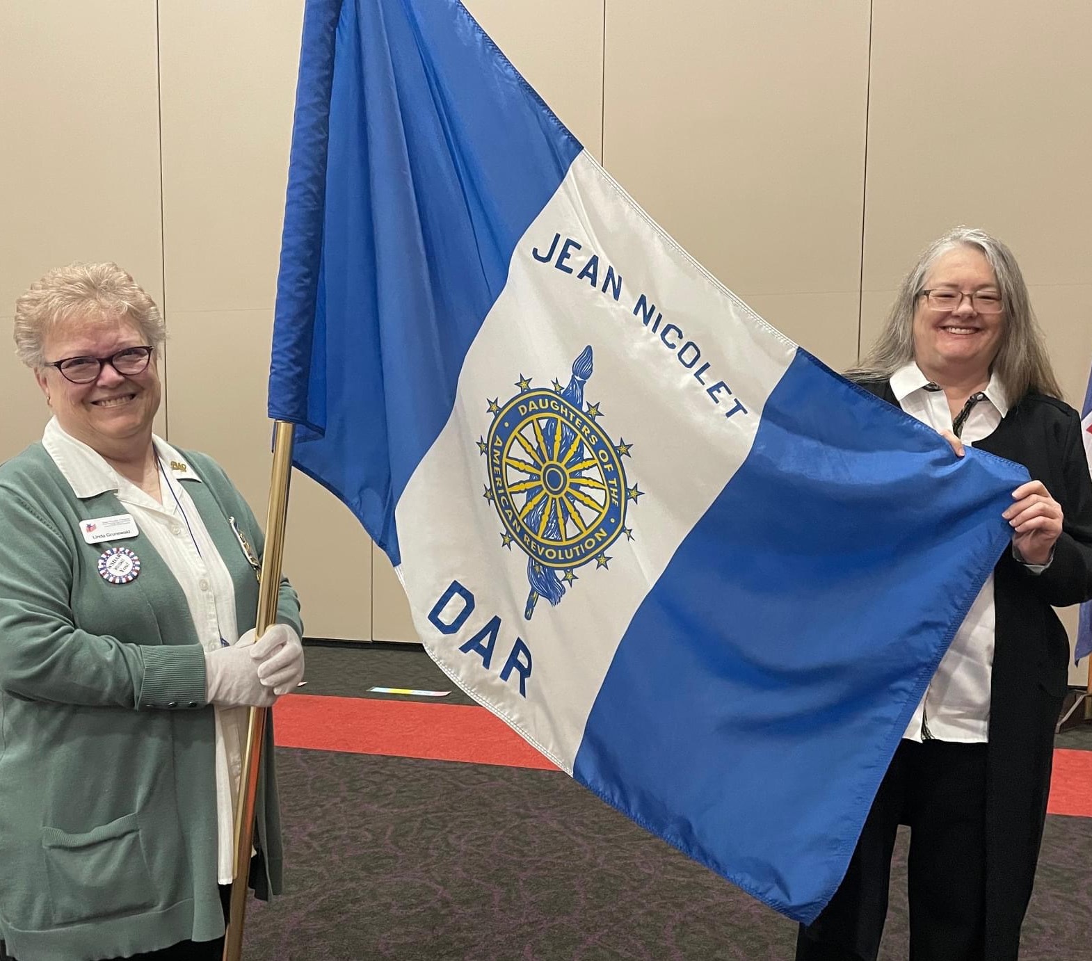 two women holding the Jean Nicolet DAR flag