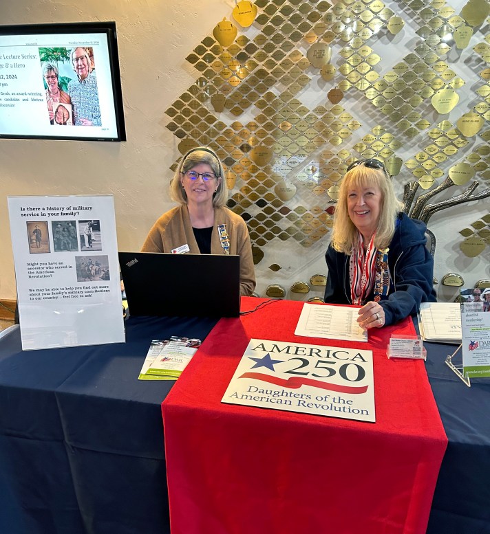 two women sitting at a presentation table