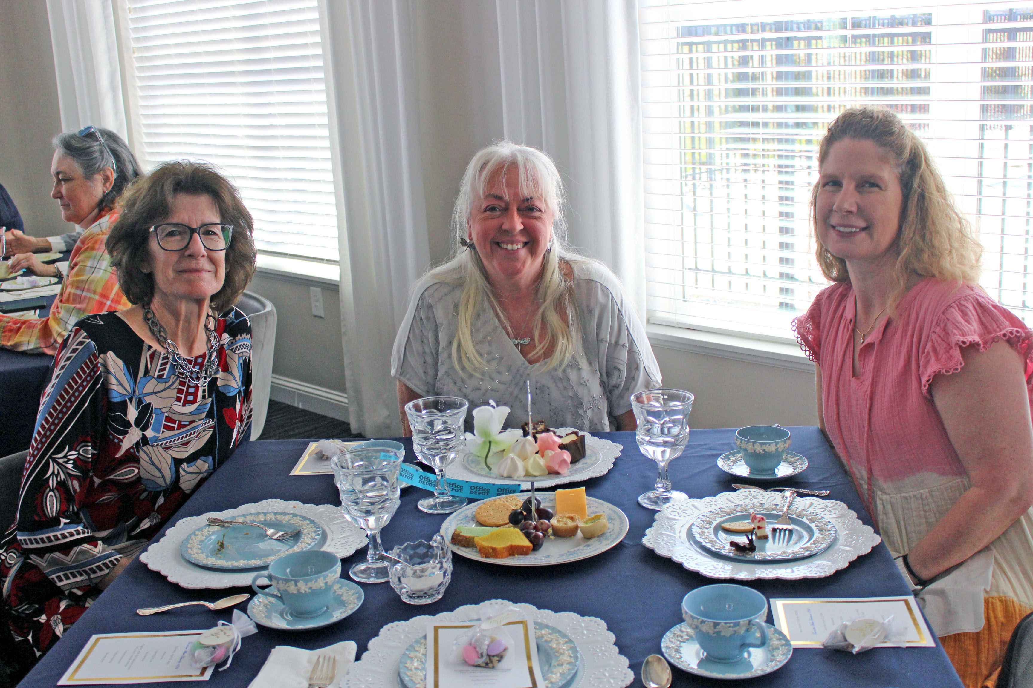 three women sitting at a table at the 2024 tea fundraiser