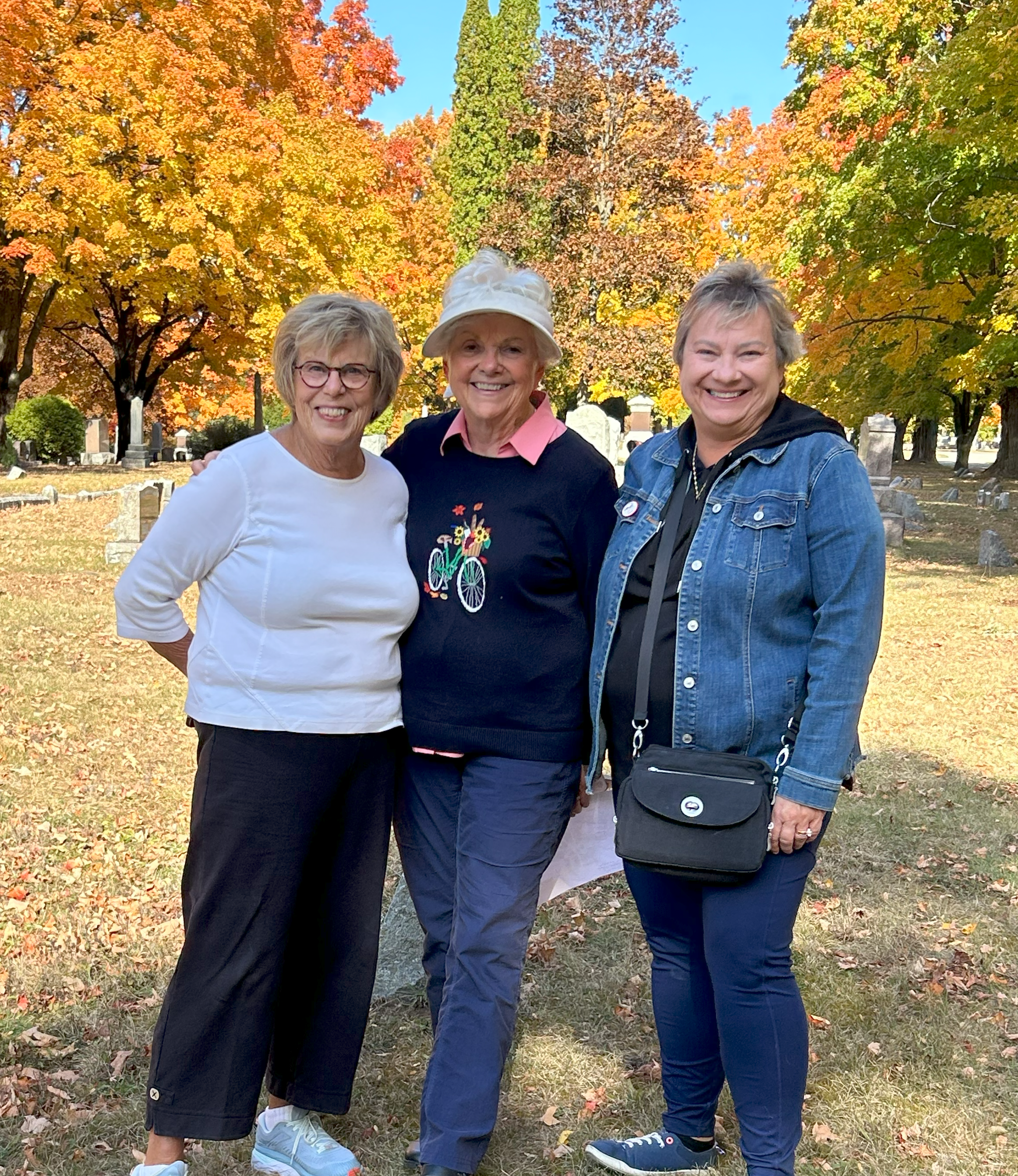 three women standing in a cemetery