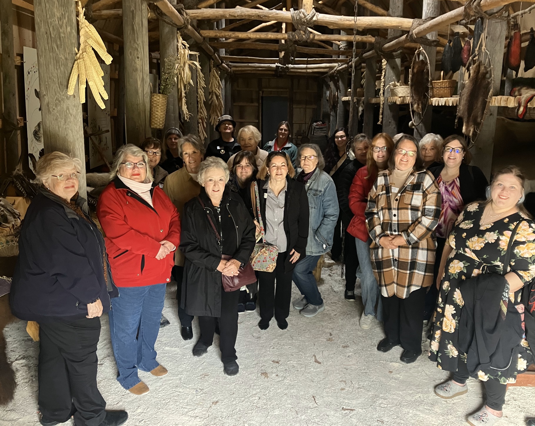 Women standing in a traditional native American long house